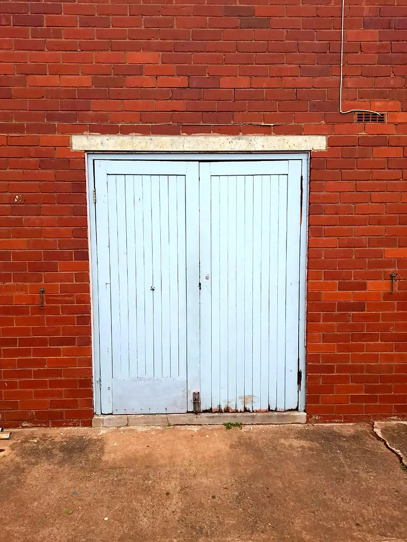 Before: worn painted timber double doors