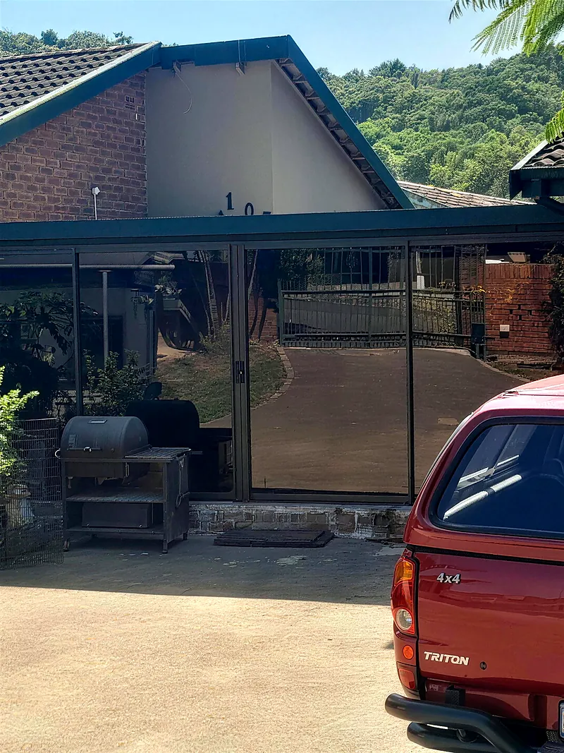 Covered patio closed in with full-height black aluminium frames